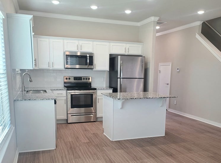 B4 Kitchen with laminate wood flooring, granite countertops, and stainless steel appliances